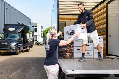 Verhuisbedrijf Tilburg laden lachend verhuiswagen uit